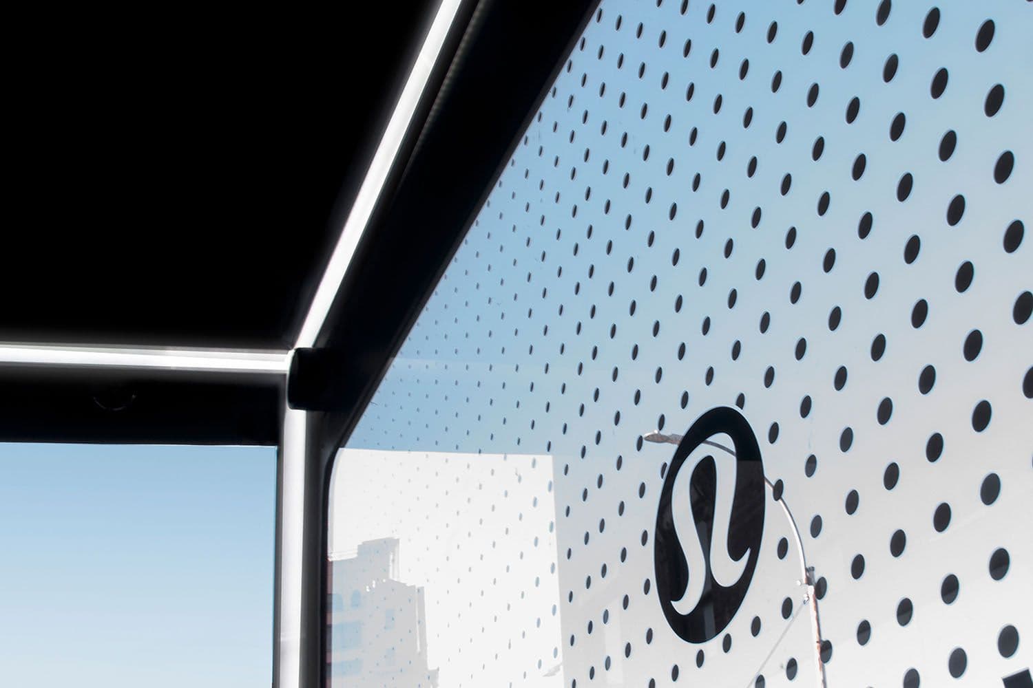 Close-up of the truck's black canopy edge against a dotted lululemon logo wall panel