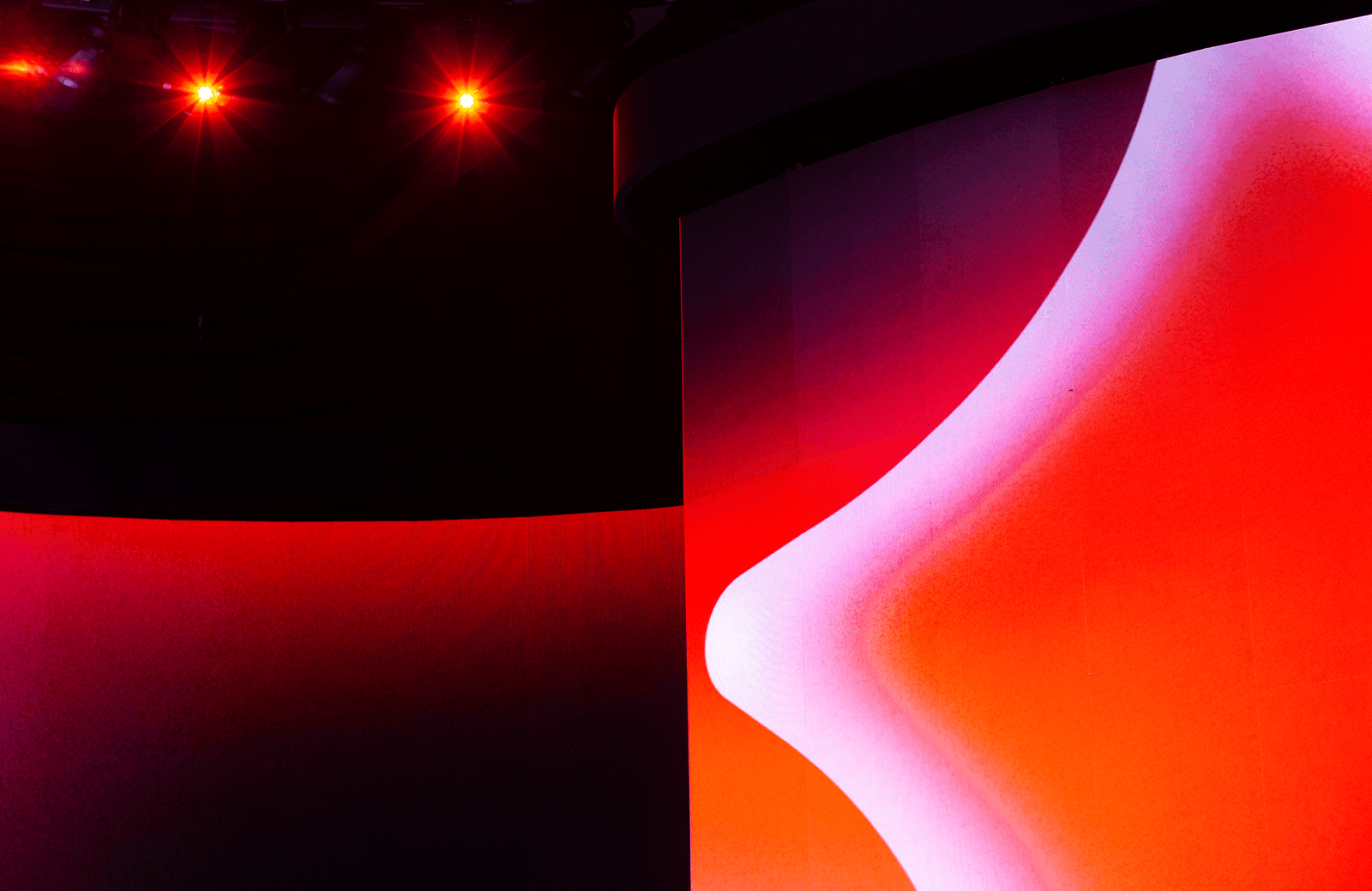 Split-screen stage lighting contrasting red on one side and white-orange on the other