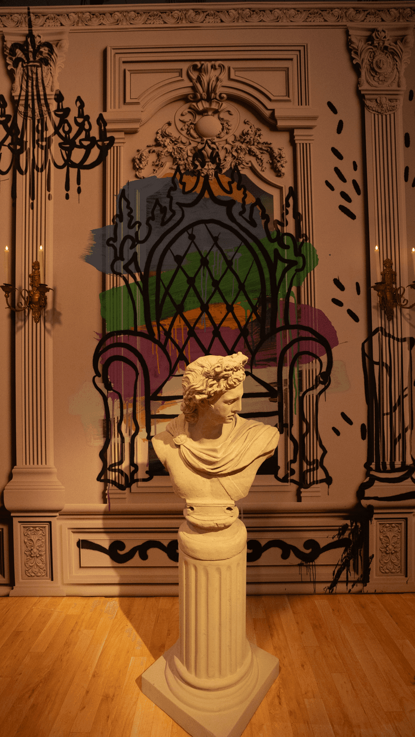 A visitor stands before a glowing blue portrait screen framed in gold, flanked by stacks of old books in a library-like room.