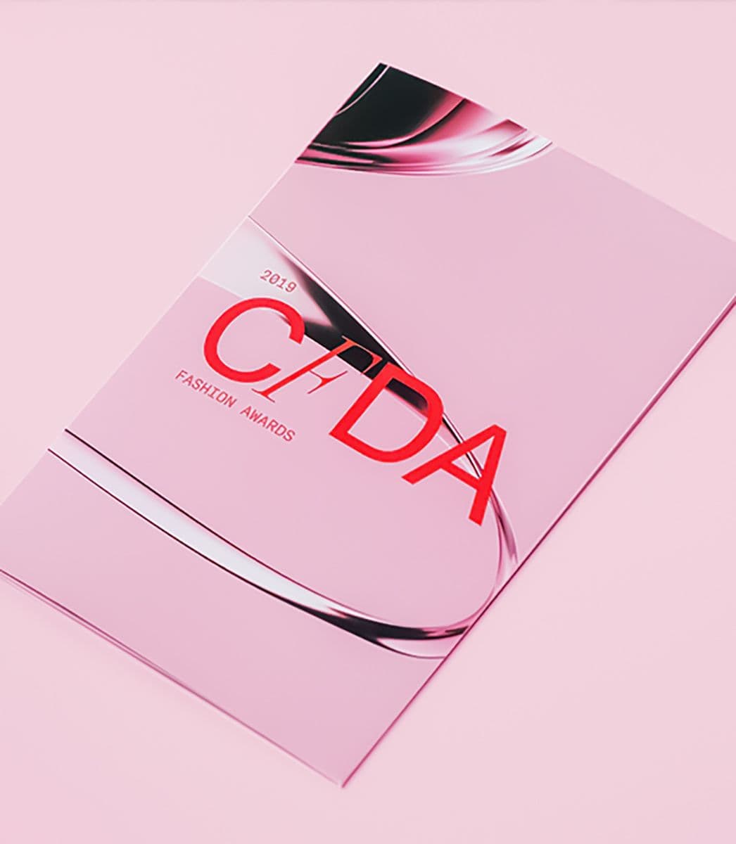 Pink CFDA Fashion Awards 2019 branded booklet mockup with a glossy black curved reflection across the cover