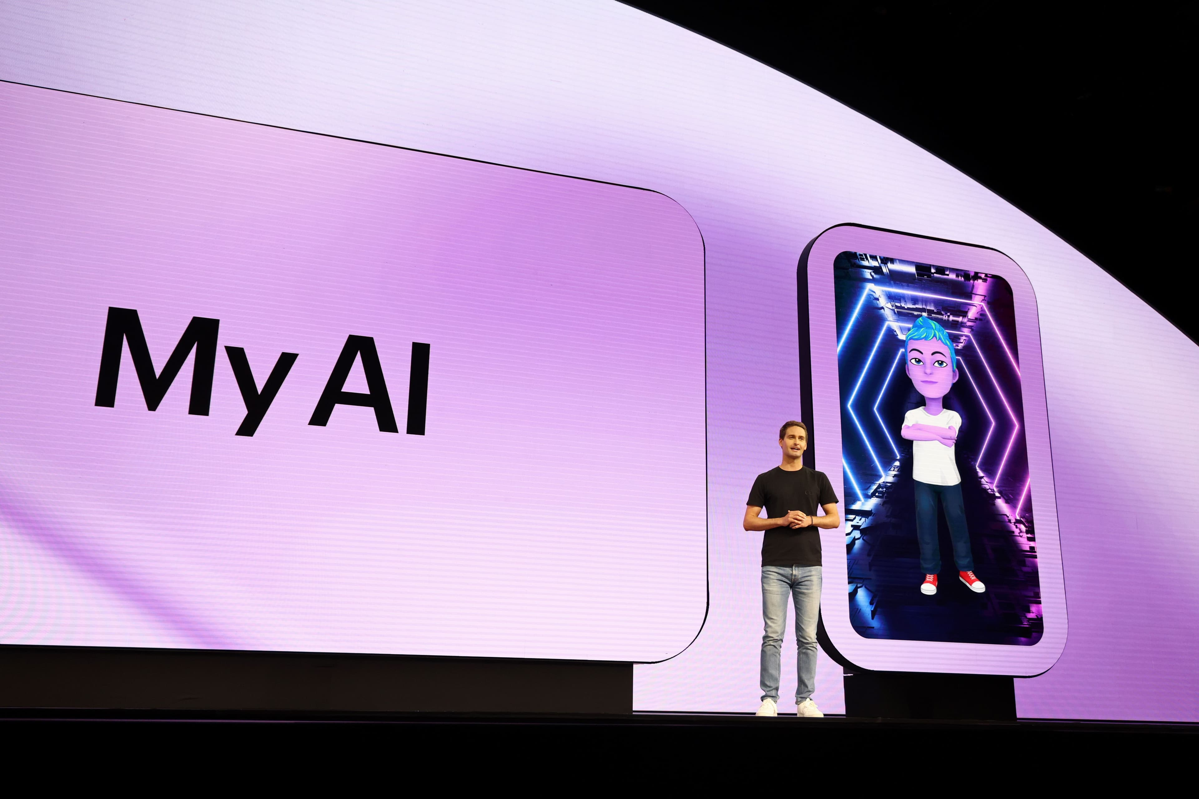 Purple-lit stage with a presenter beside a large screen showing the My AI avatar.