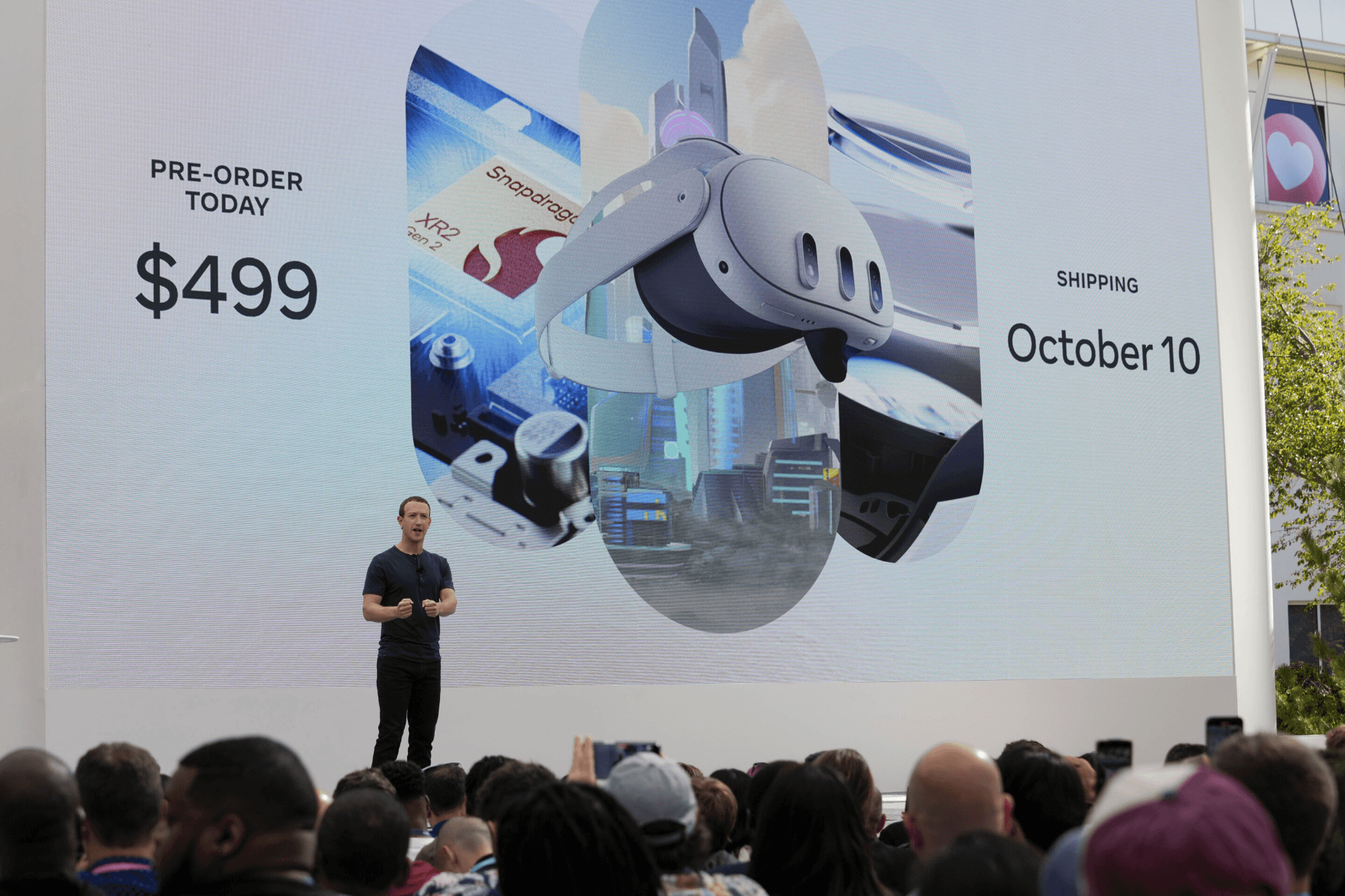 Presenter on stage in front of a screen showing Quest 3 pricing and an October 10 ship date.