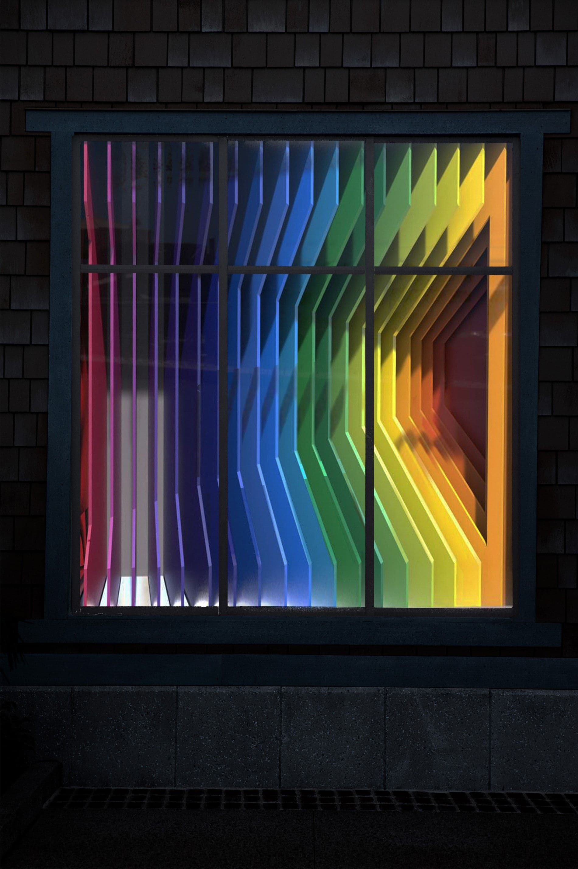 Wood-shingled storefront window at night showing a rainbow-gradient folded panel display seen through the glass.