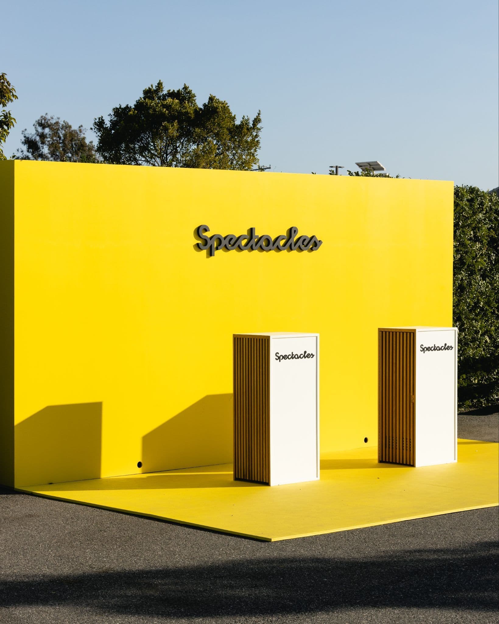 Yellow wall reading 'Spectacles' beside two pedestals.