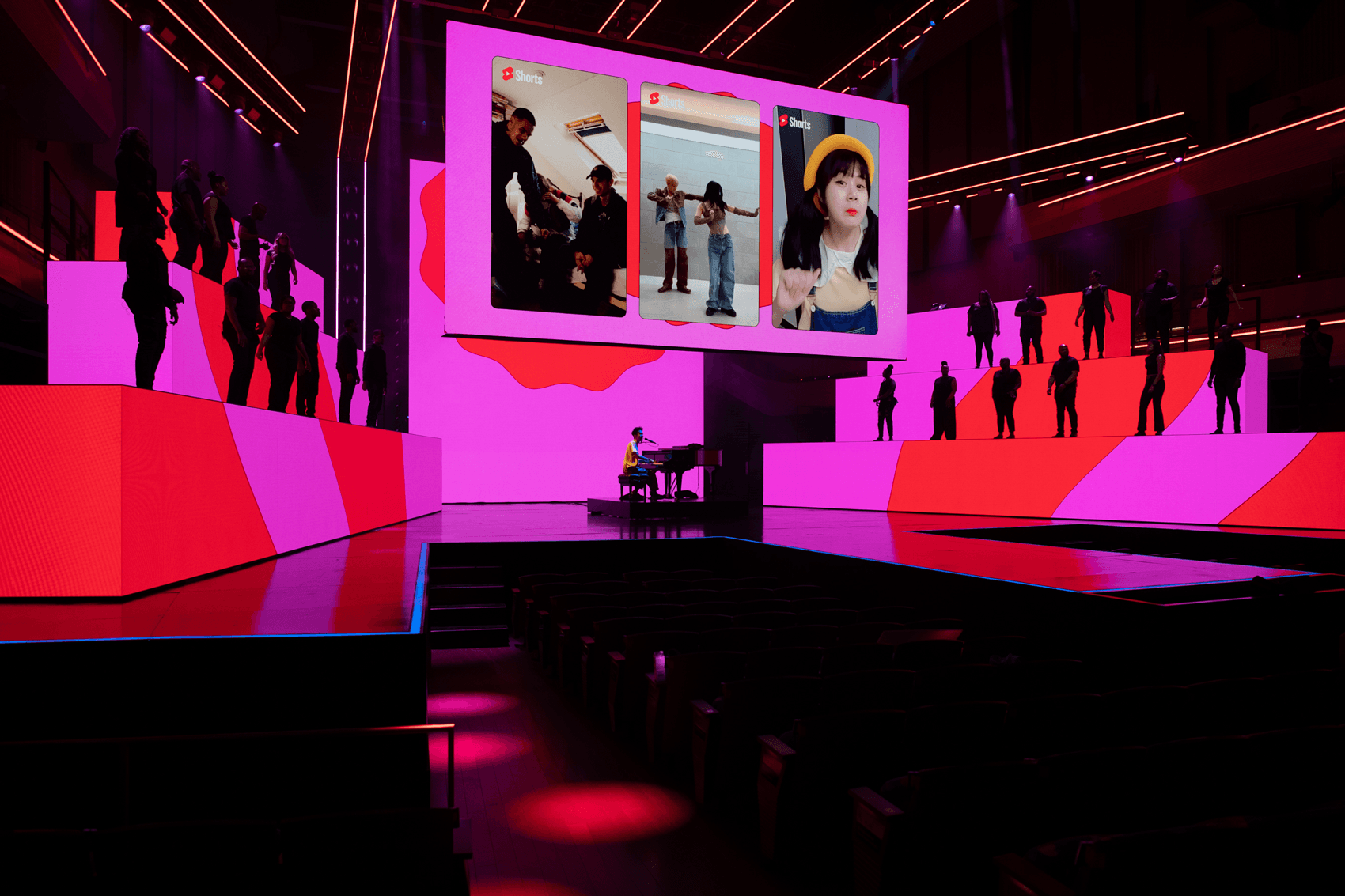 Stage screen displaying a grid of photos above a pink and red lit set with silhouetted dancers