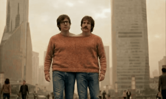 AI-generated video still of two identical men in orange sweaters standing side by side against a city skyline.