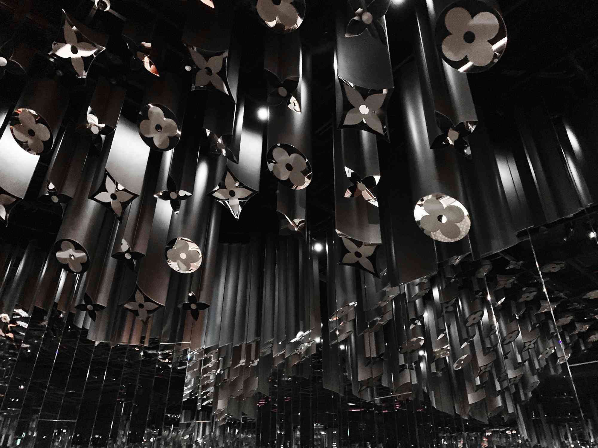 Close-up of black faceted flower-shaped ornaments hanging from above.