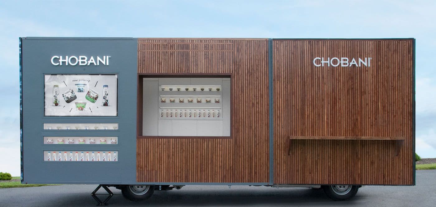 Full side view of the wood-slat trailer showing the menu screen, dispenser, and wheels.