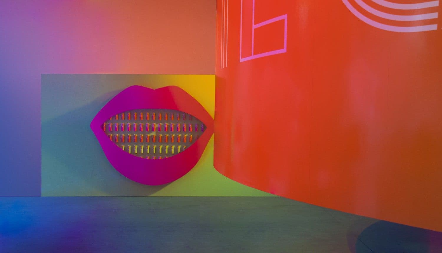 Orange wall with an illustrated mouth graphic showing braces, alongside abstract line patterns.