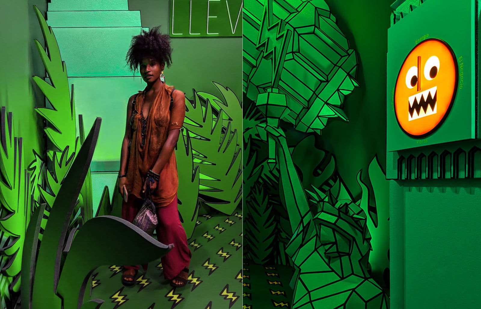 Woman in a green-lit jungle-themed installation with an illustrated leaf backdrop and a glowing orange emoji face.