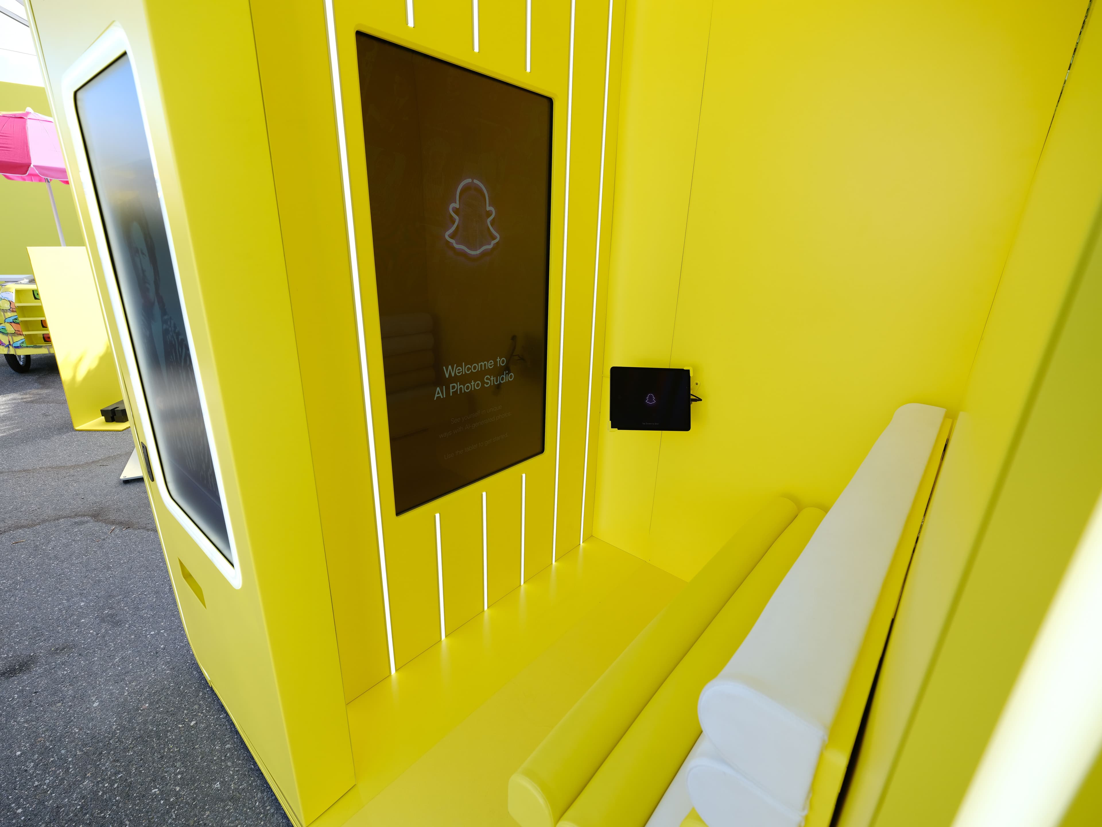Yellow ribbed kiosk with an interactive touchscreen display outdoors.