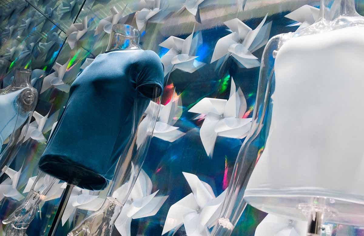 Close-up of a dark bottle-shaped ornament surrounded by white paper pinwheel decorations and iridescent light.
