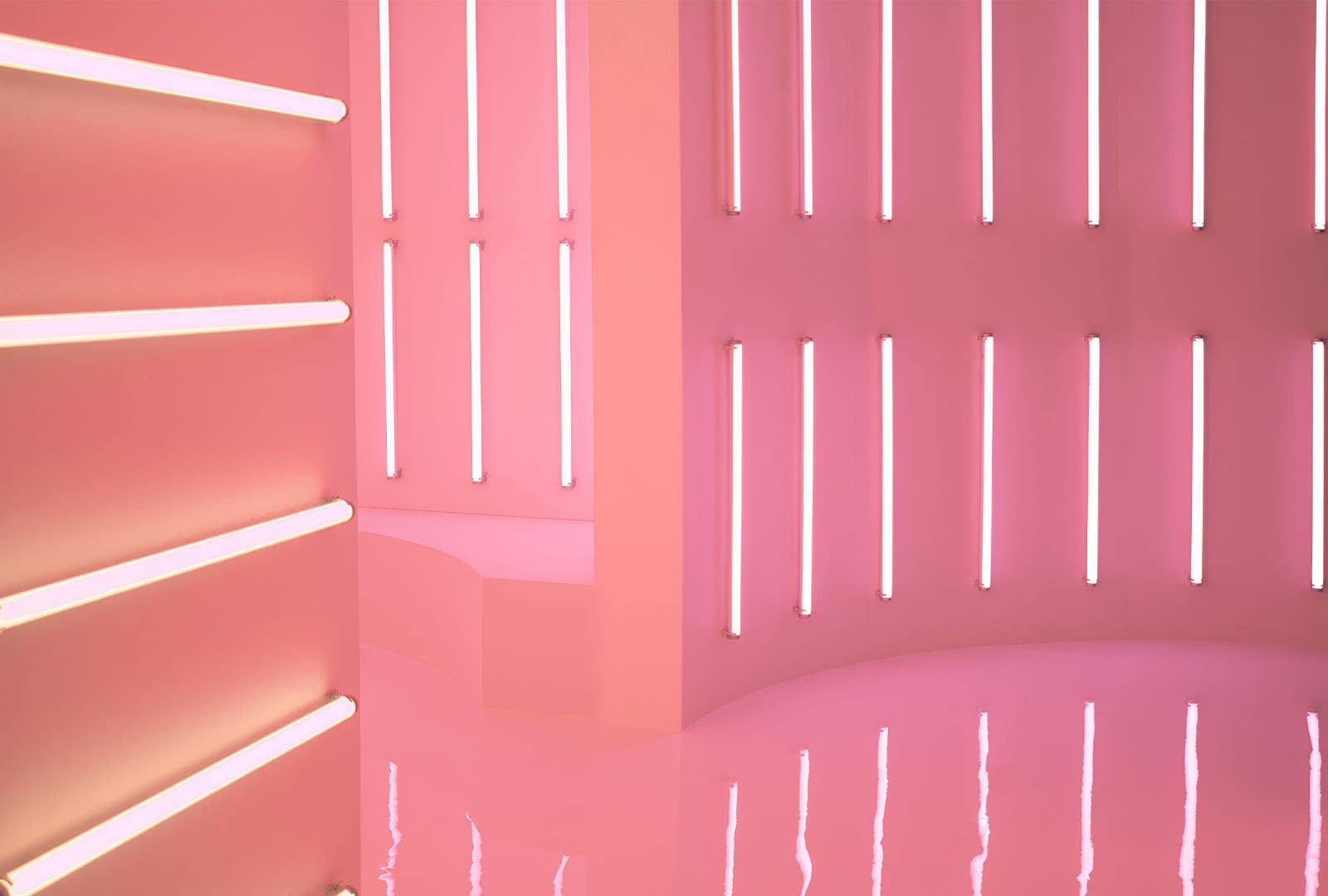 Soft peach and pink chamber with a curved wall of horizontal neon strips.