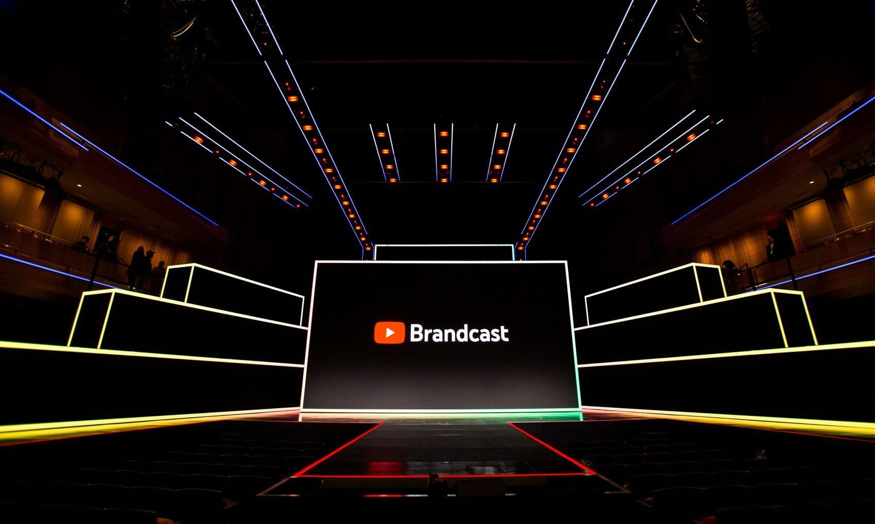 Stage screen reading "Brandcast" above a symmetrical yellow and black lit stage