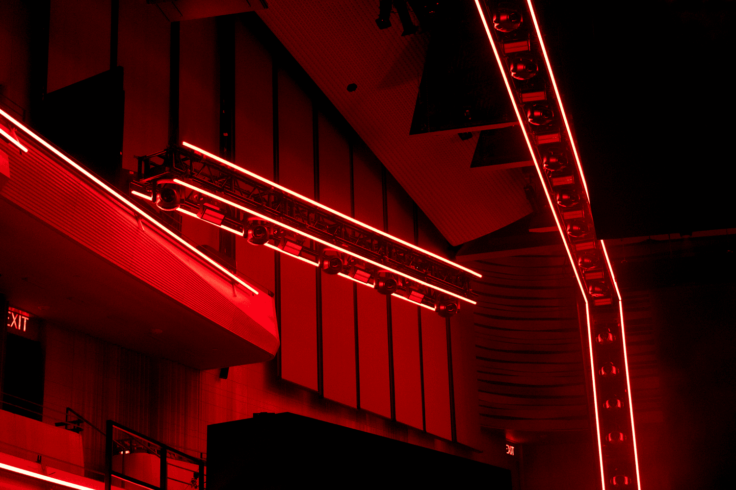 Red-lit venue architecture with angular red neon strips along a jagged stage structure.