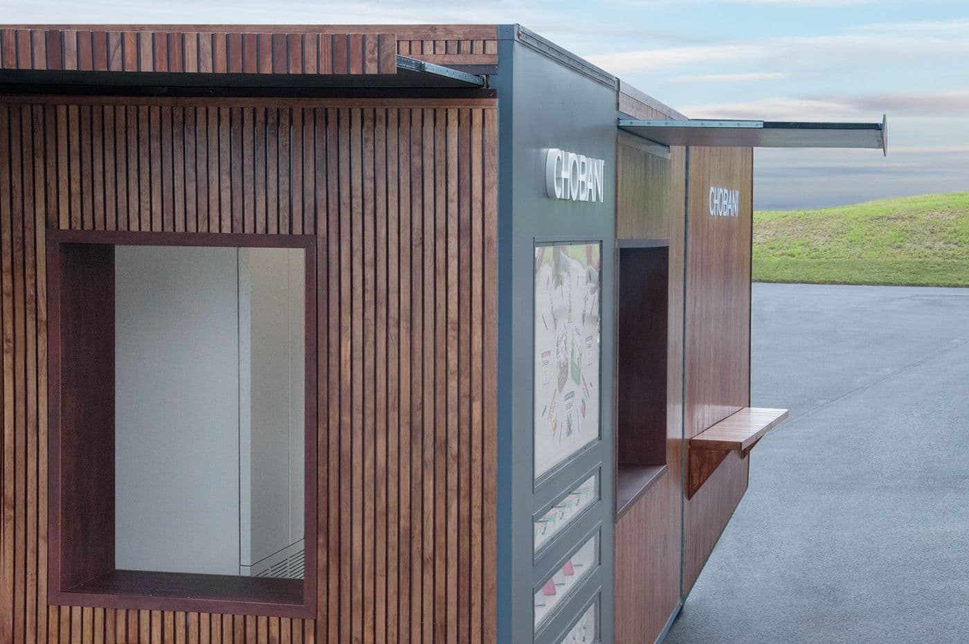 Close-up of the trailer's wood-slat corner showing a glass serving window.