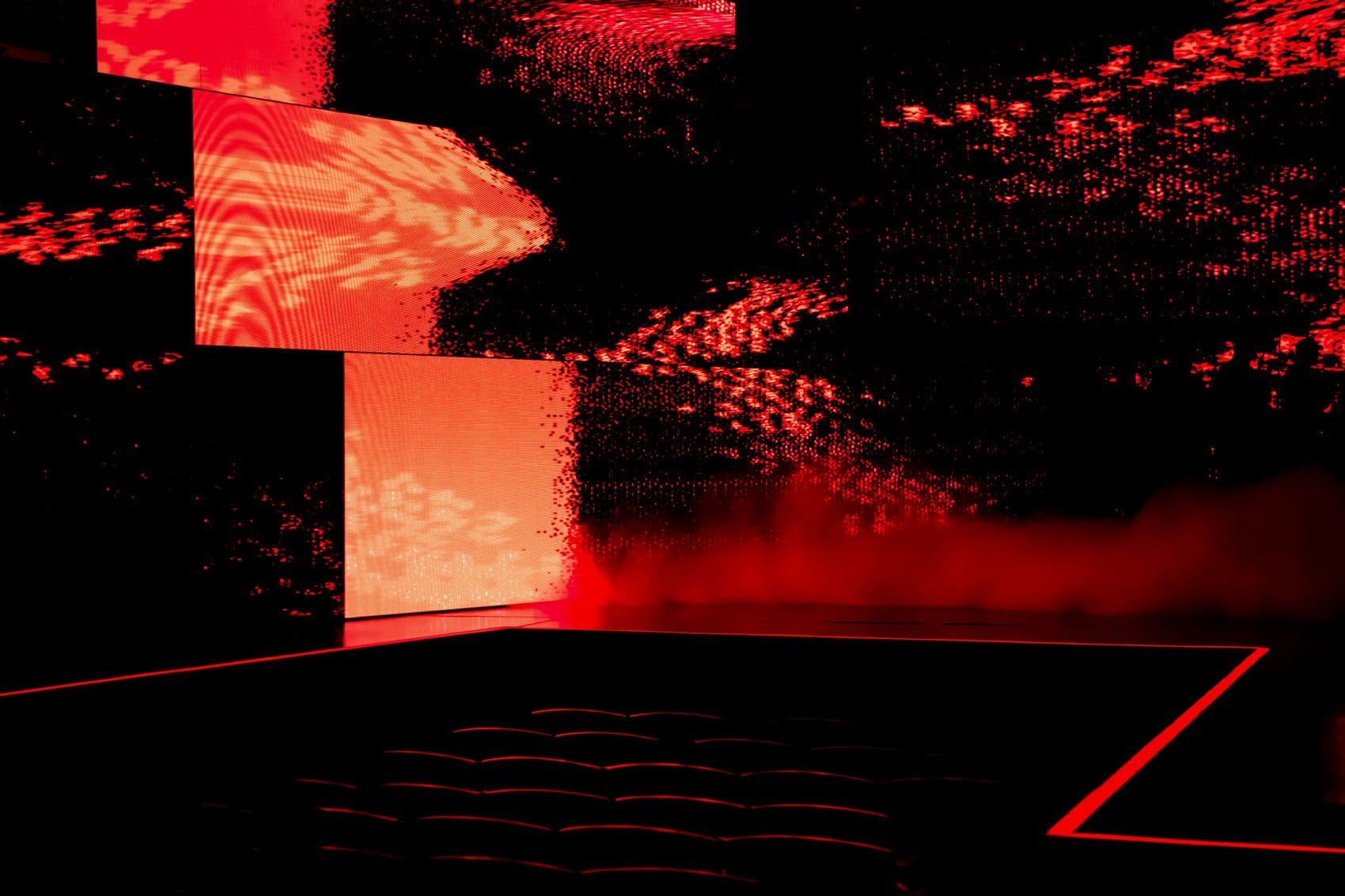 Abstract red and orange pixelated pattern projected across the stage screens