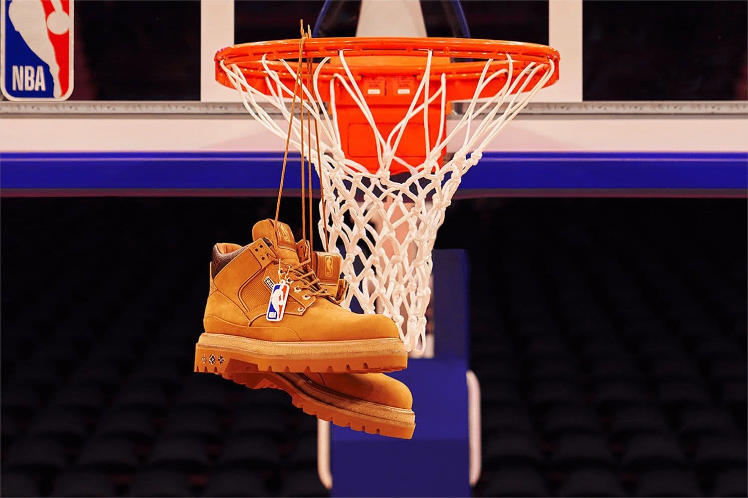 Basketball hoop and net with a pair of tan boots hanging from the rim.