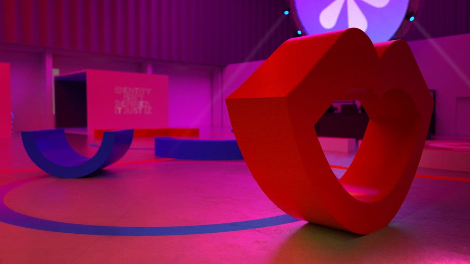Pink and blue exhibit room with a red heart-shaped sculpture and a butterfly shape suspended above.