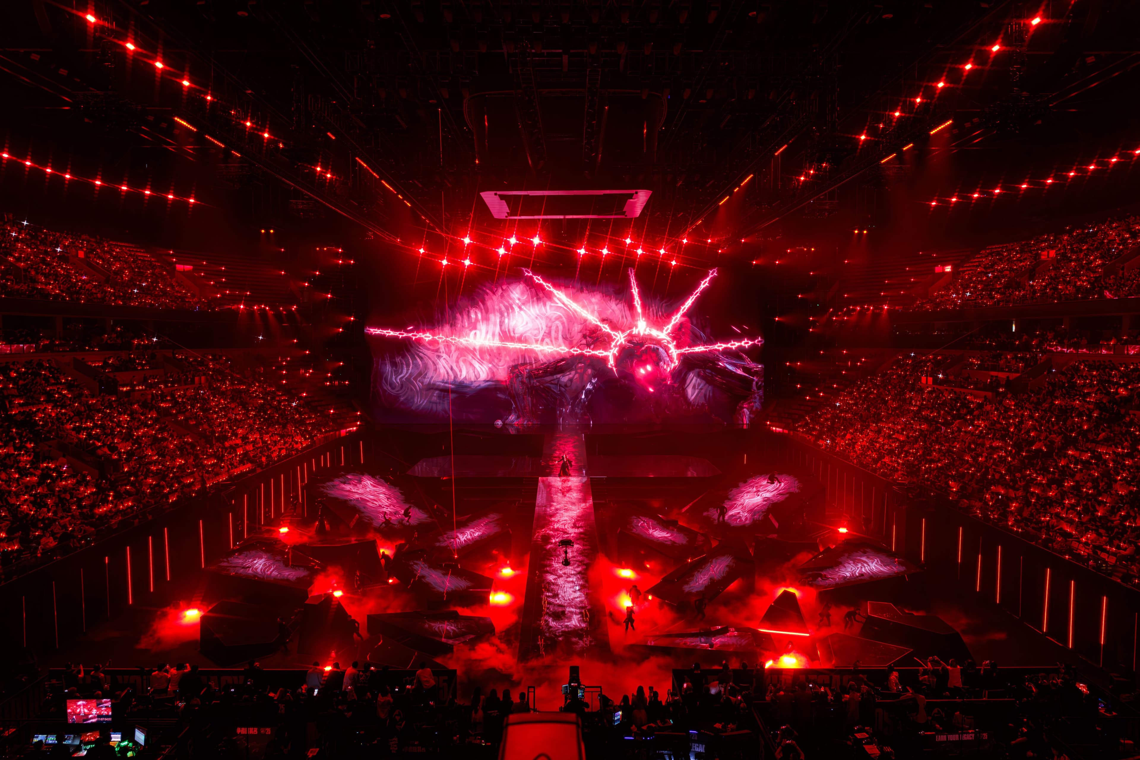 Wide stage shot with red flame-effect lighting and pyrotechnics in front of a large crowd.