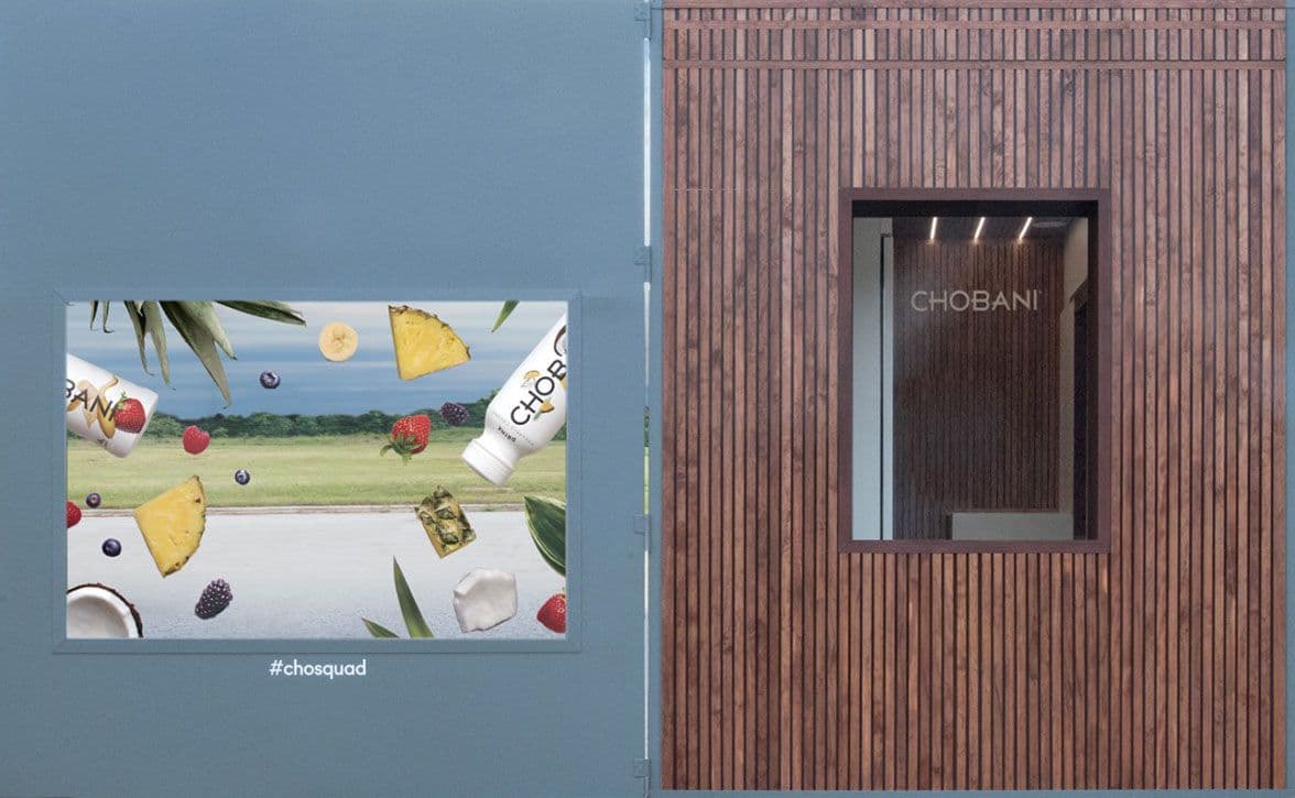 Exterior detail of a teal panel with fruit imagery beside the wood-slat serving window.