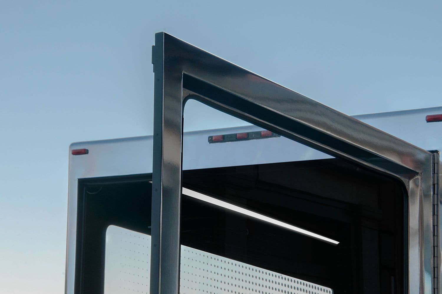 Close-up corner detail of the mobile studio truck's frame against a blue sky