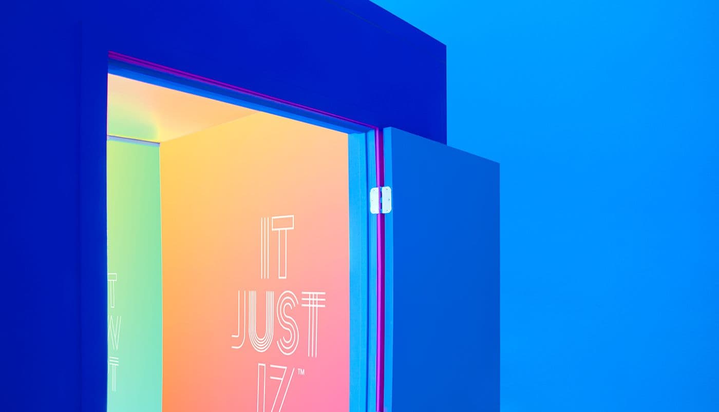 Blue architectural steps with a rainbow gradient panel displaying the words "IT JUST IZ".