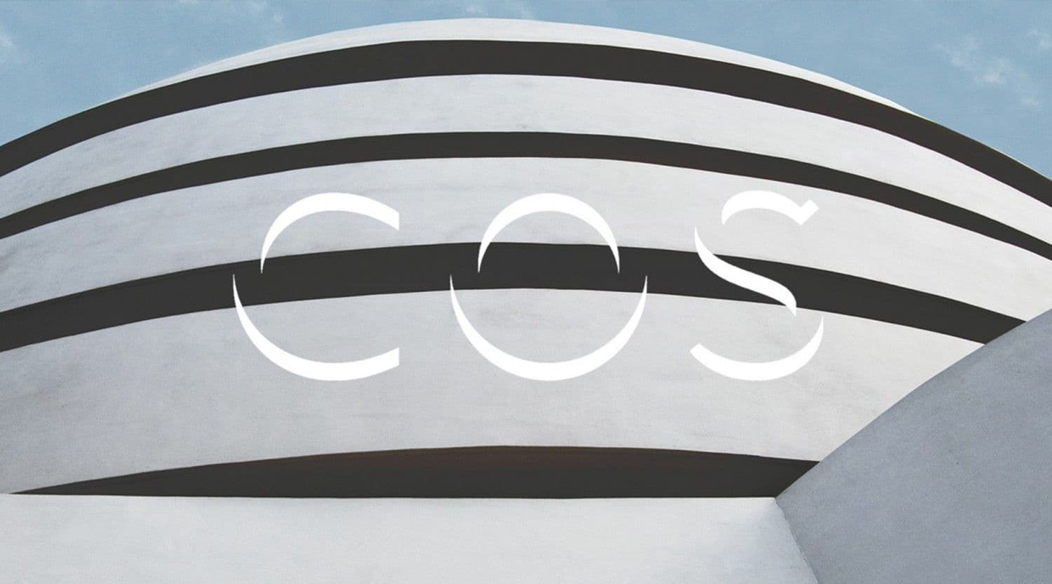 Guggenheim Museum's curved facade with the COS logo overlaid across the spiral bands