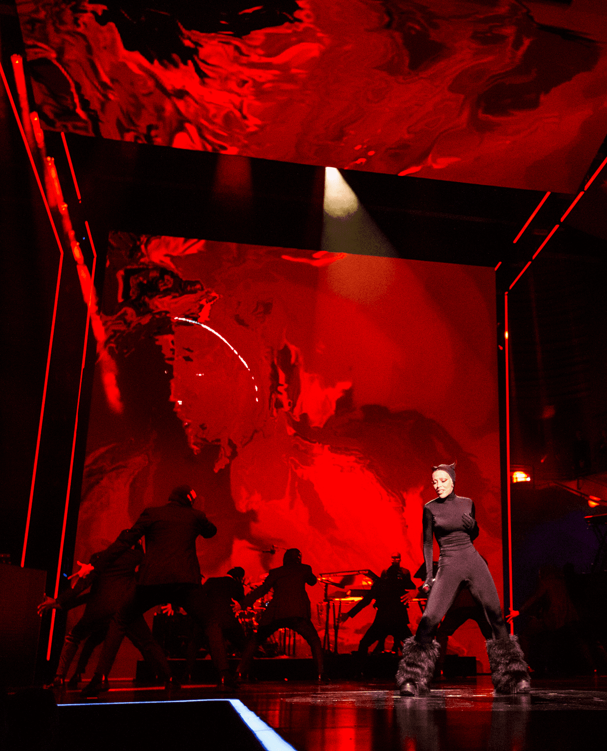 Angled red stage screens forming a geometric pattern with a dark red glow