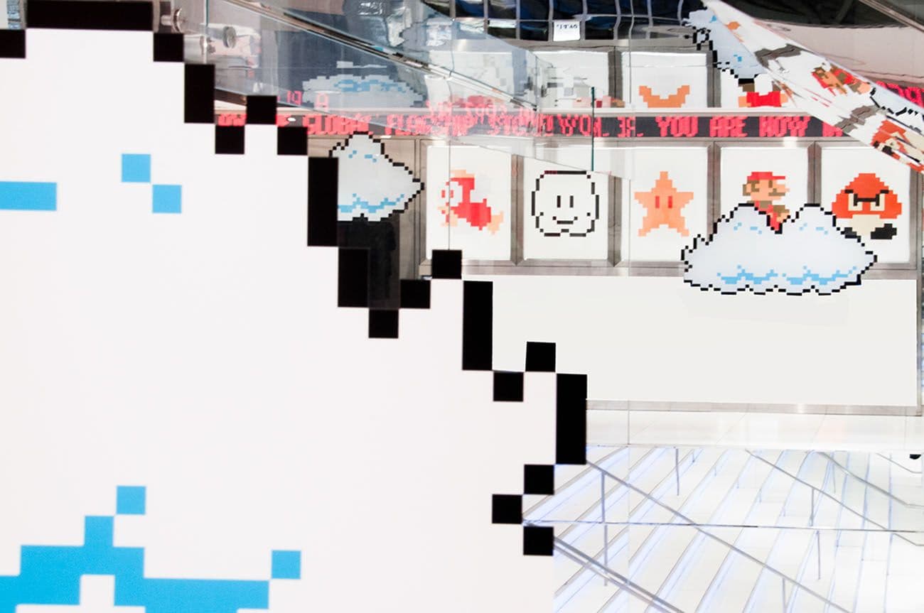 Pixel-art cloud graphics and framed character portraits on a white gallery wall, partially obscured by cloud cutouts.