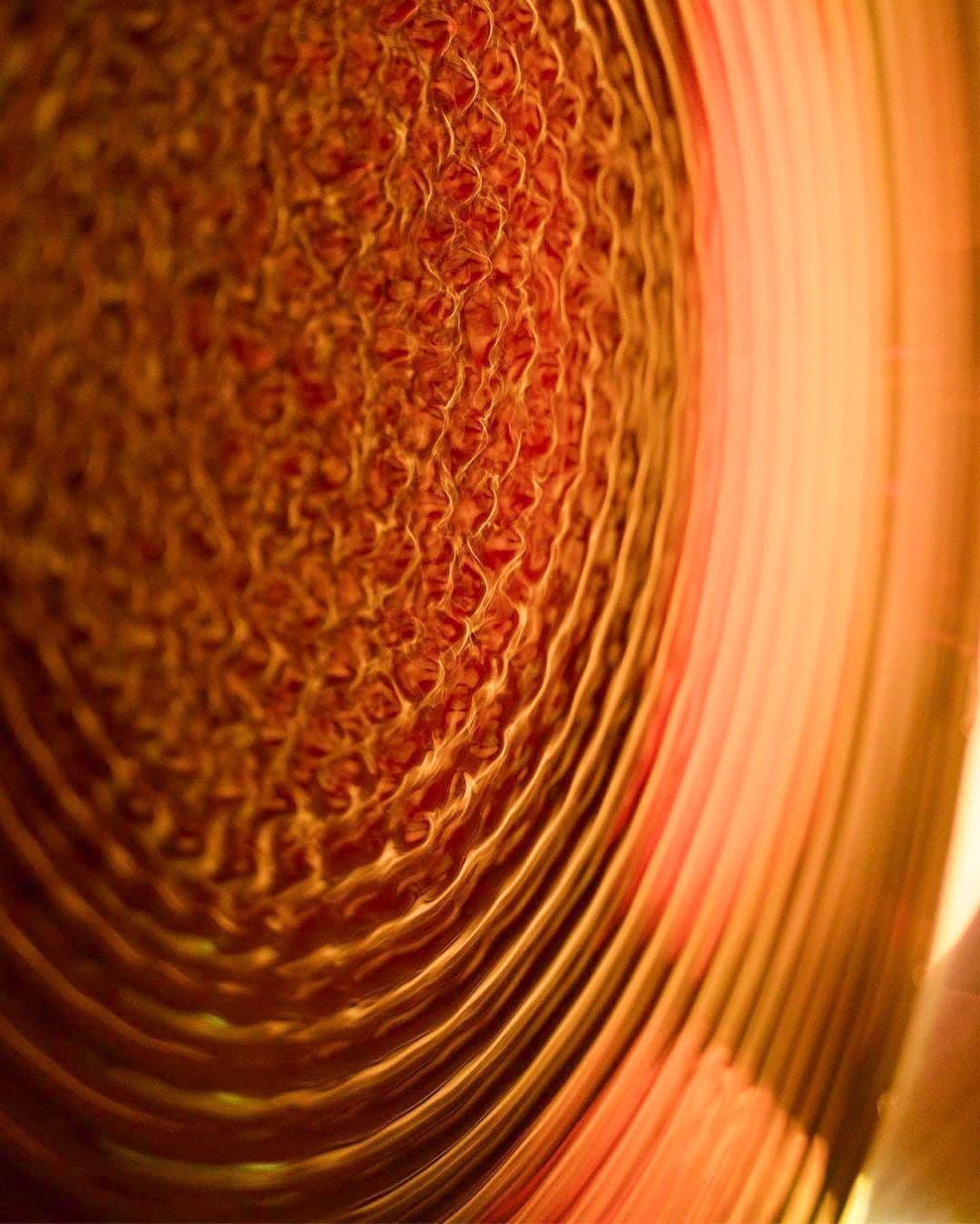 Macro shot of a swirling orange and copper textured pattern.