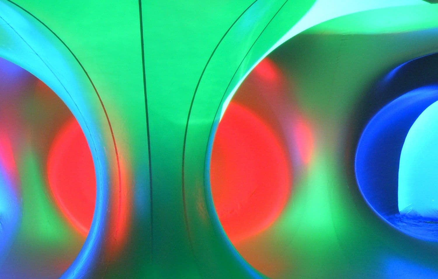 Green and red circular tunnel shapes viewed through arched openings.