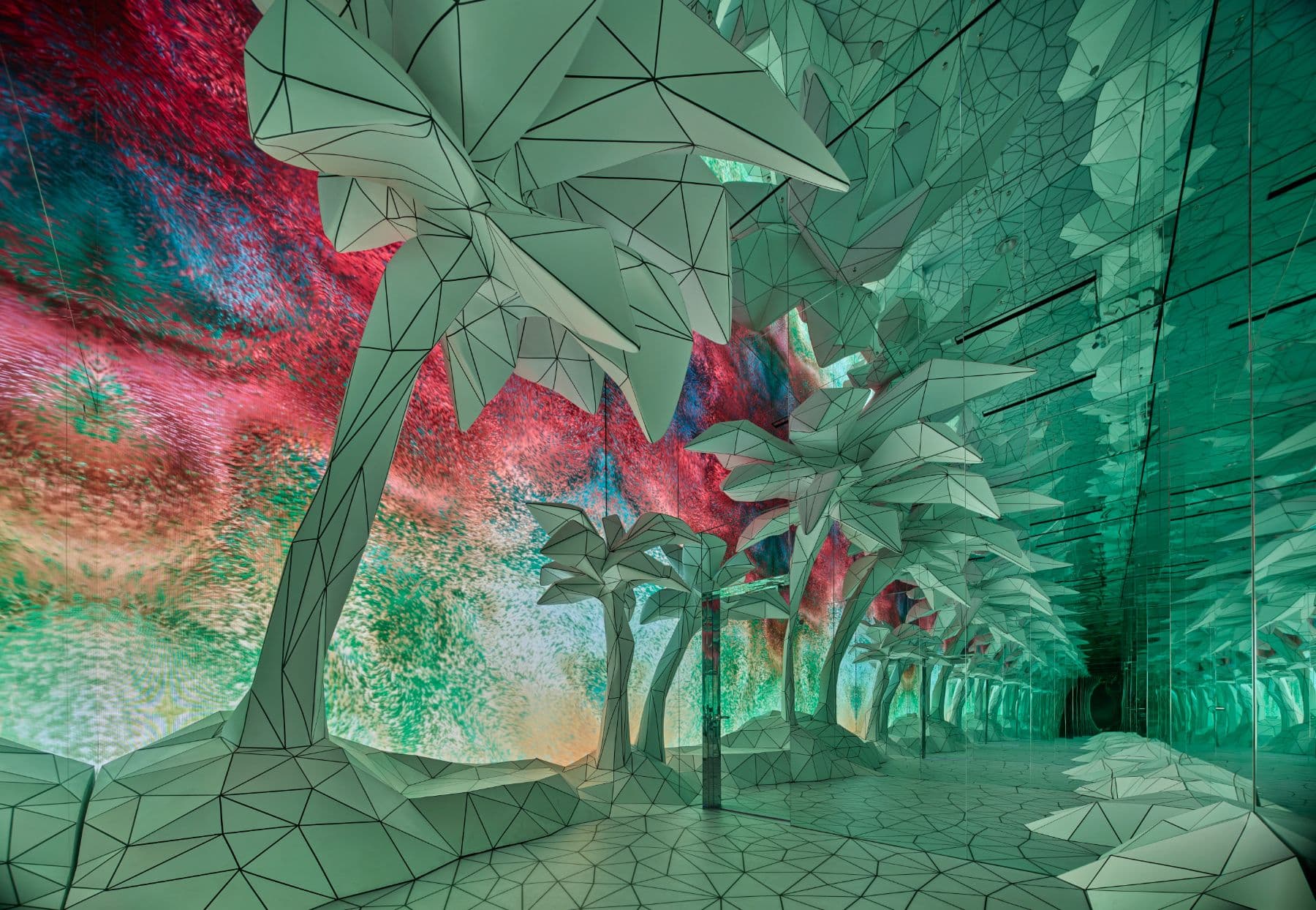 Immersive blue-lit tunnel installation with faceted low-poly palm trees and reflective floor.