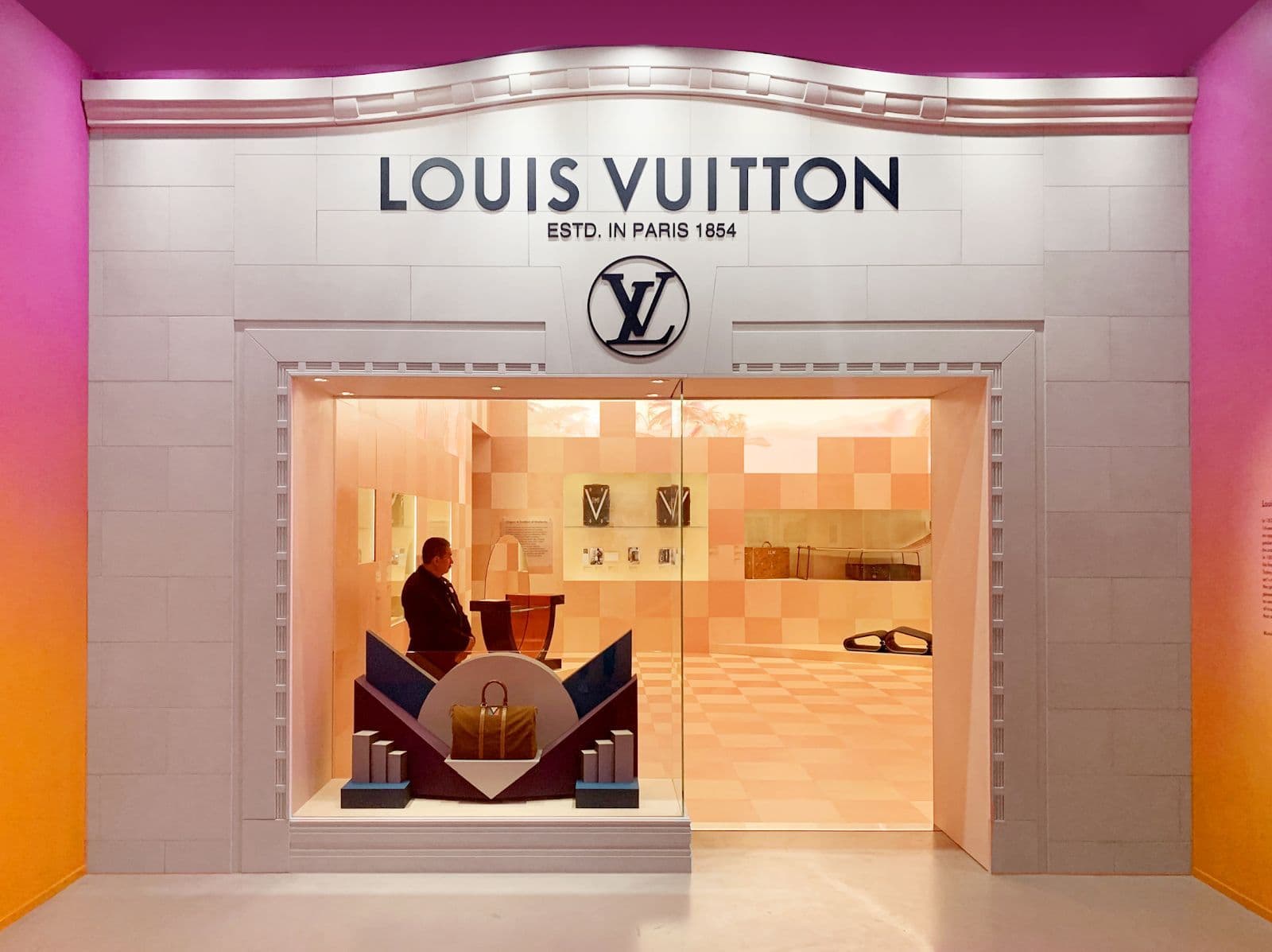Louis Vuitton storefront with a rainbow gradient facade and illuminated entrance.