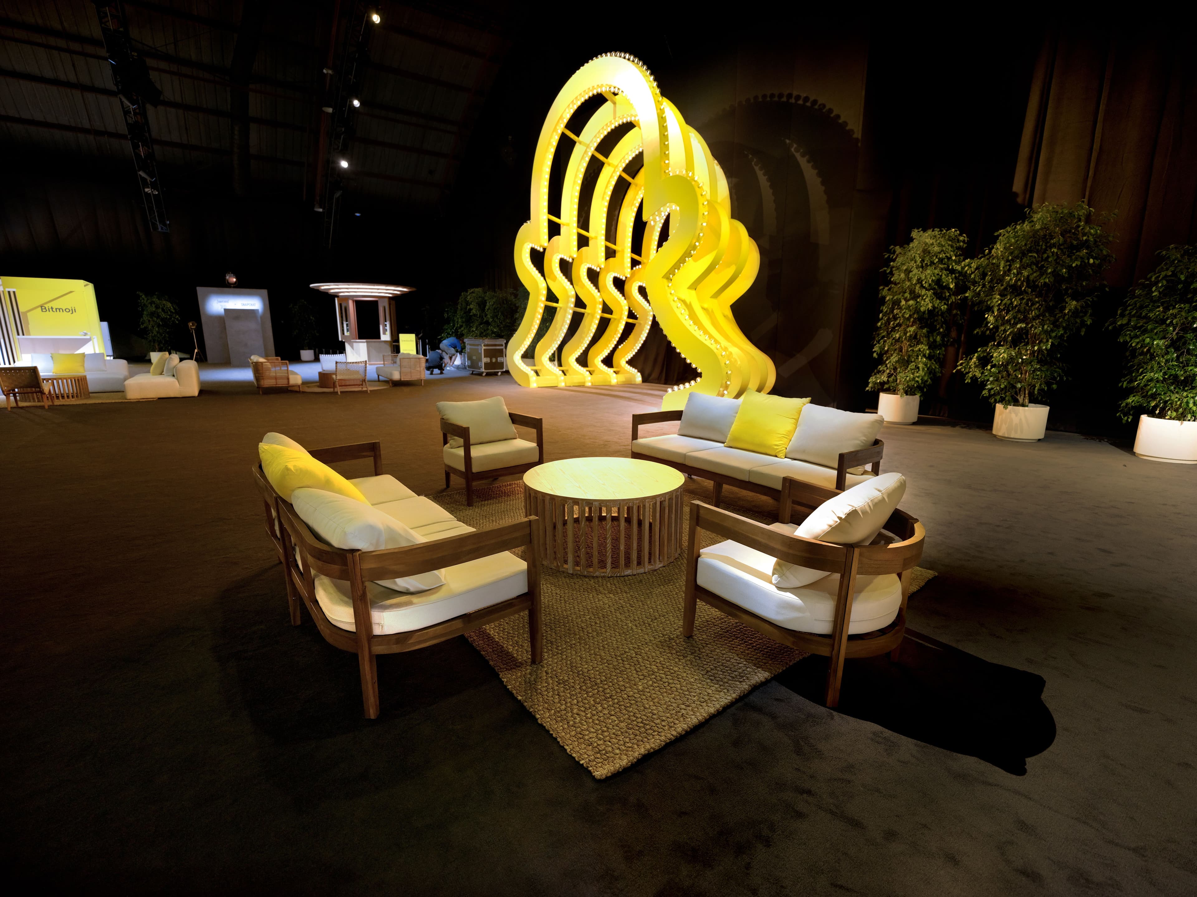 snapchat logo sculpture installation beside a lounge seating area with sofas and a low table.