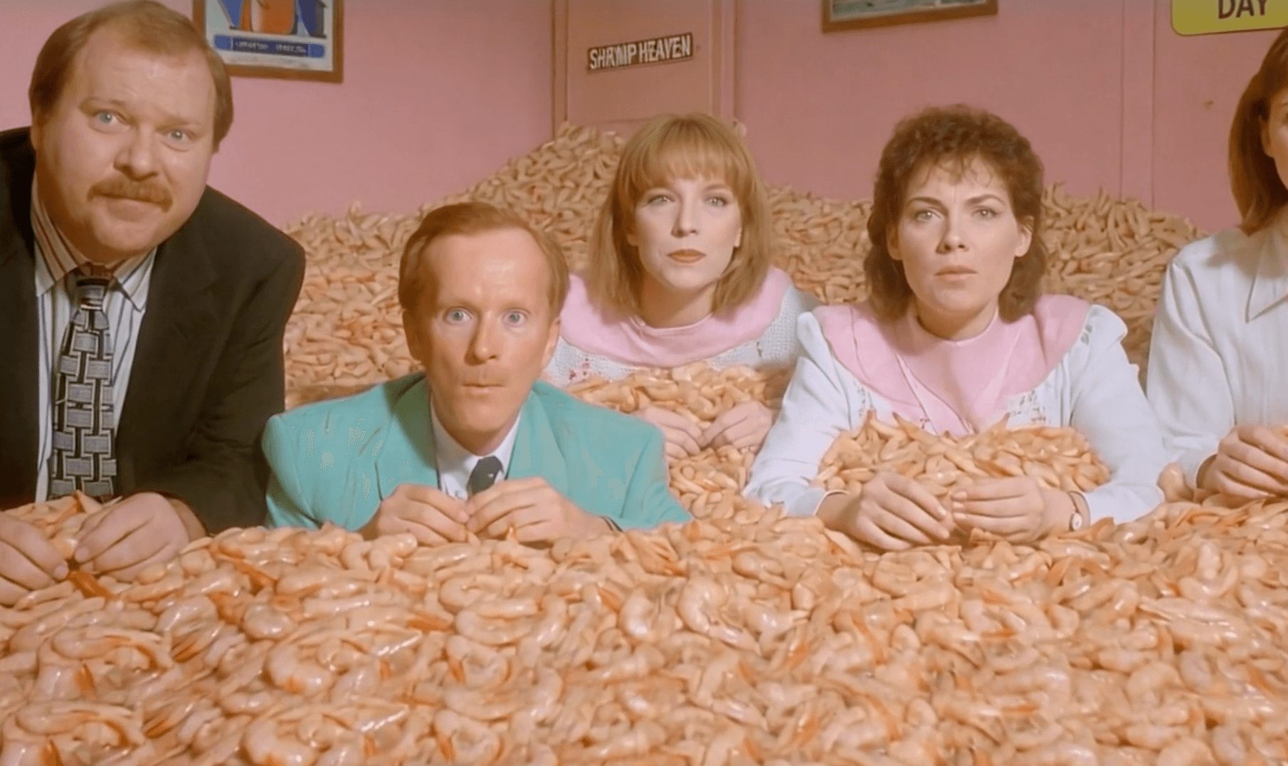 AI-generated video still of a family surrounded by an overwhelming pile of shrimp on a dining table.