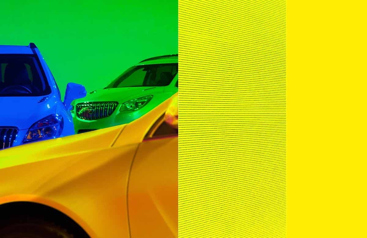 Green-lit cars beside a vertical panel with fine yellow striped texture.