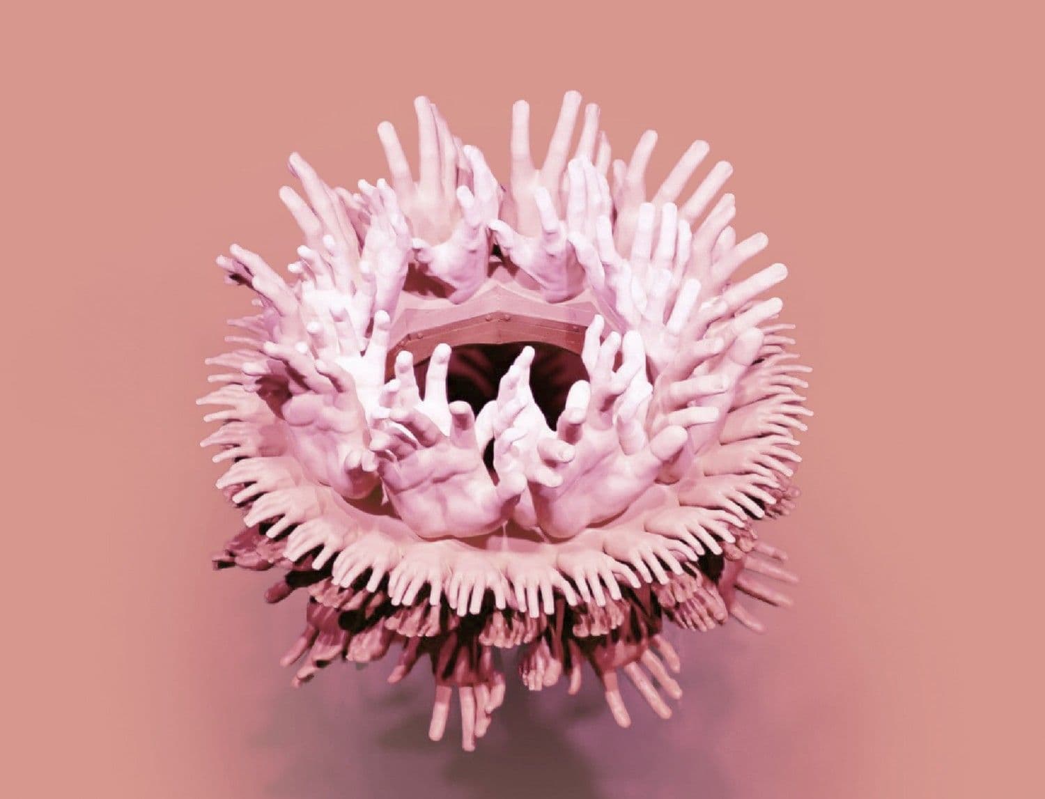Sculptural pink form covered in dense radiating tentacle-like spikes surrounding a central opening.