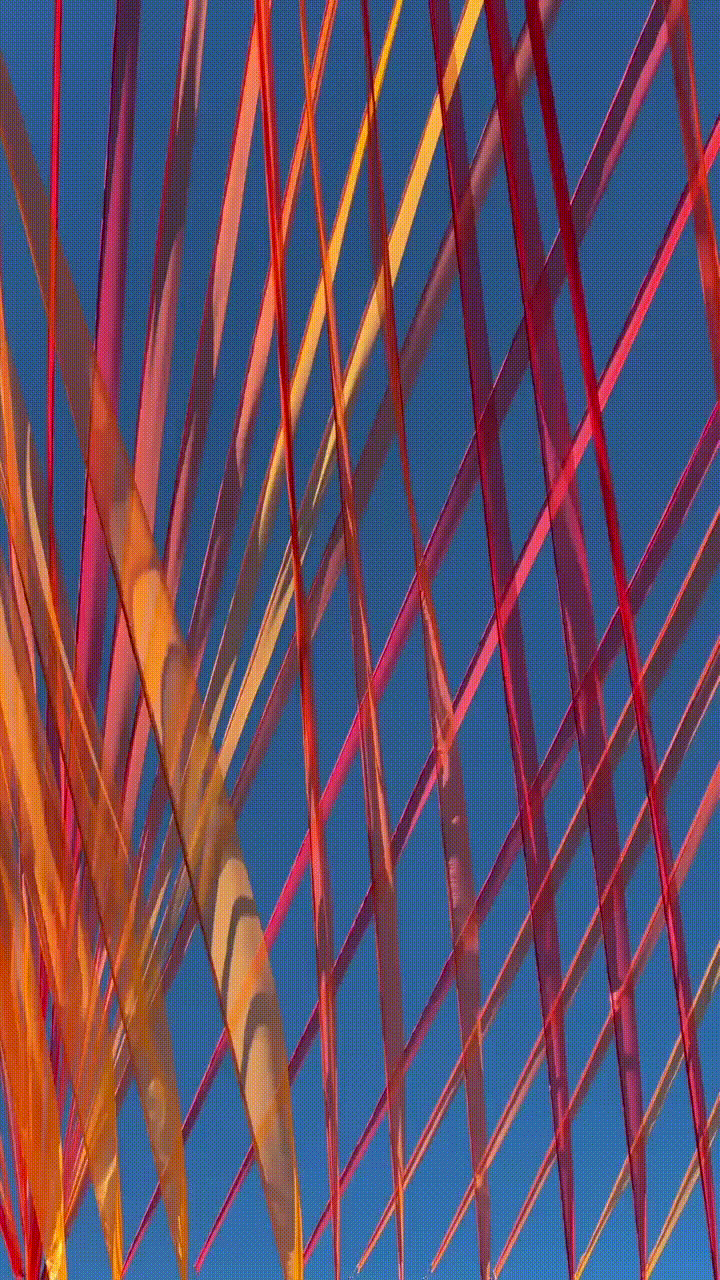 Colorful ribbons crisscrossing against a blue sky.