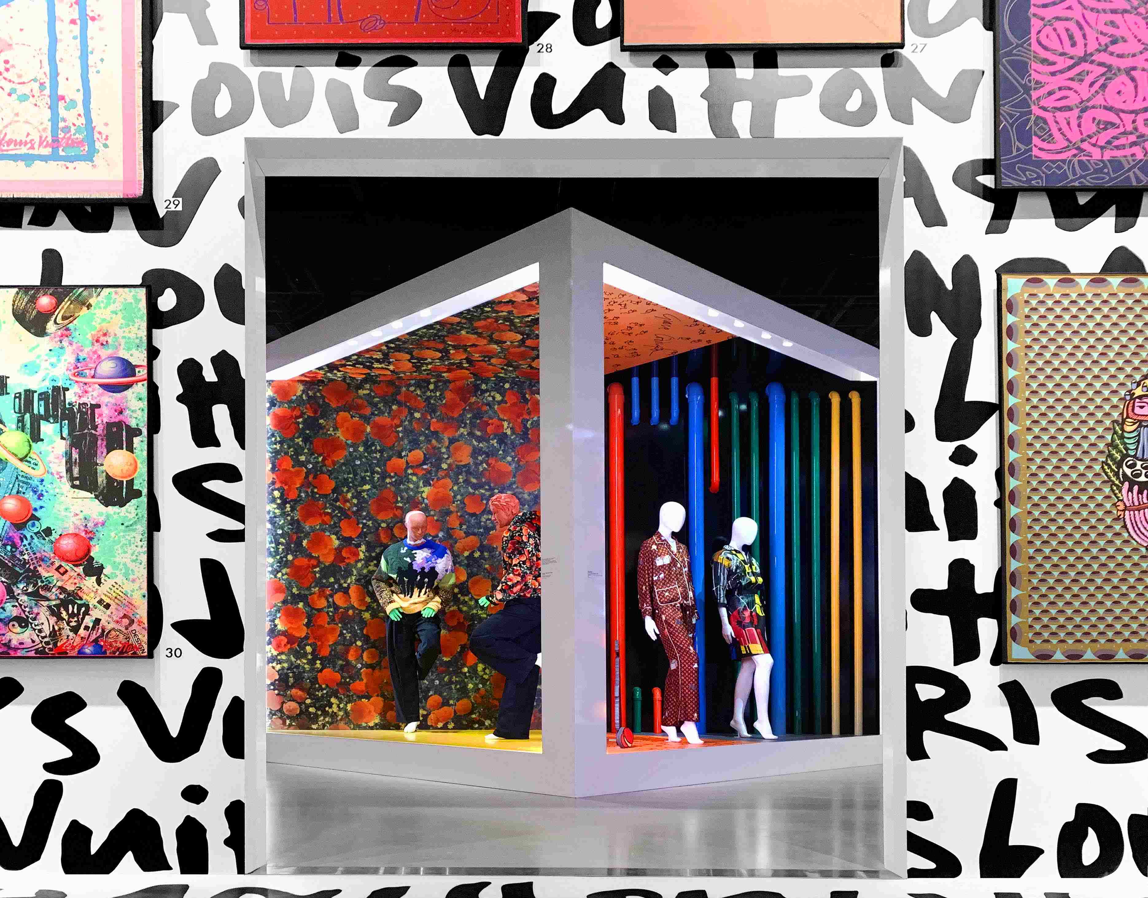 Gallery corridor with colorful abstract artwork and a mannequin dressed in a striped outfit.