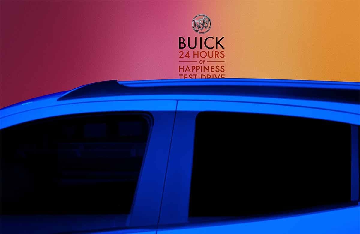 Buick "24 Hours of Happiness Test Drive" text displayed above the roofline of a blue car against a gradient background.