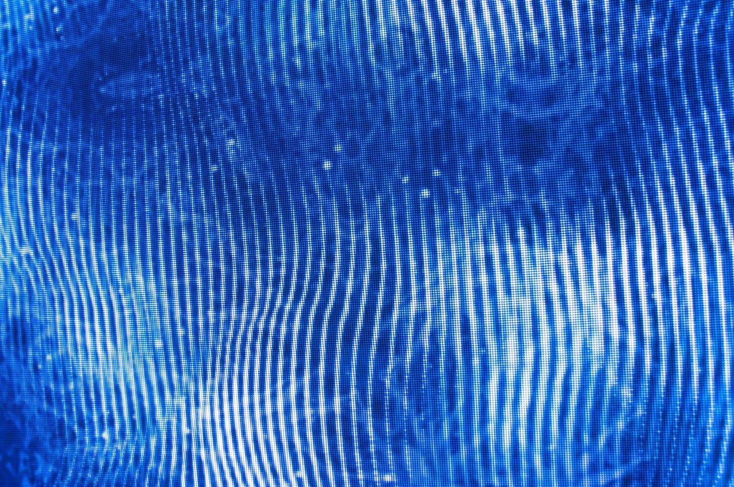 Close-up of vertical blue light ripples forming a dense wave pattern.