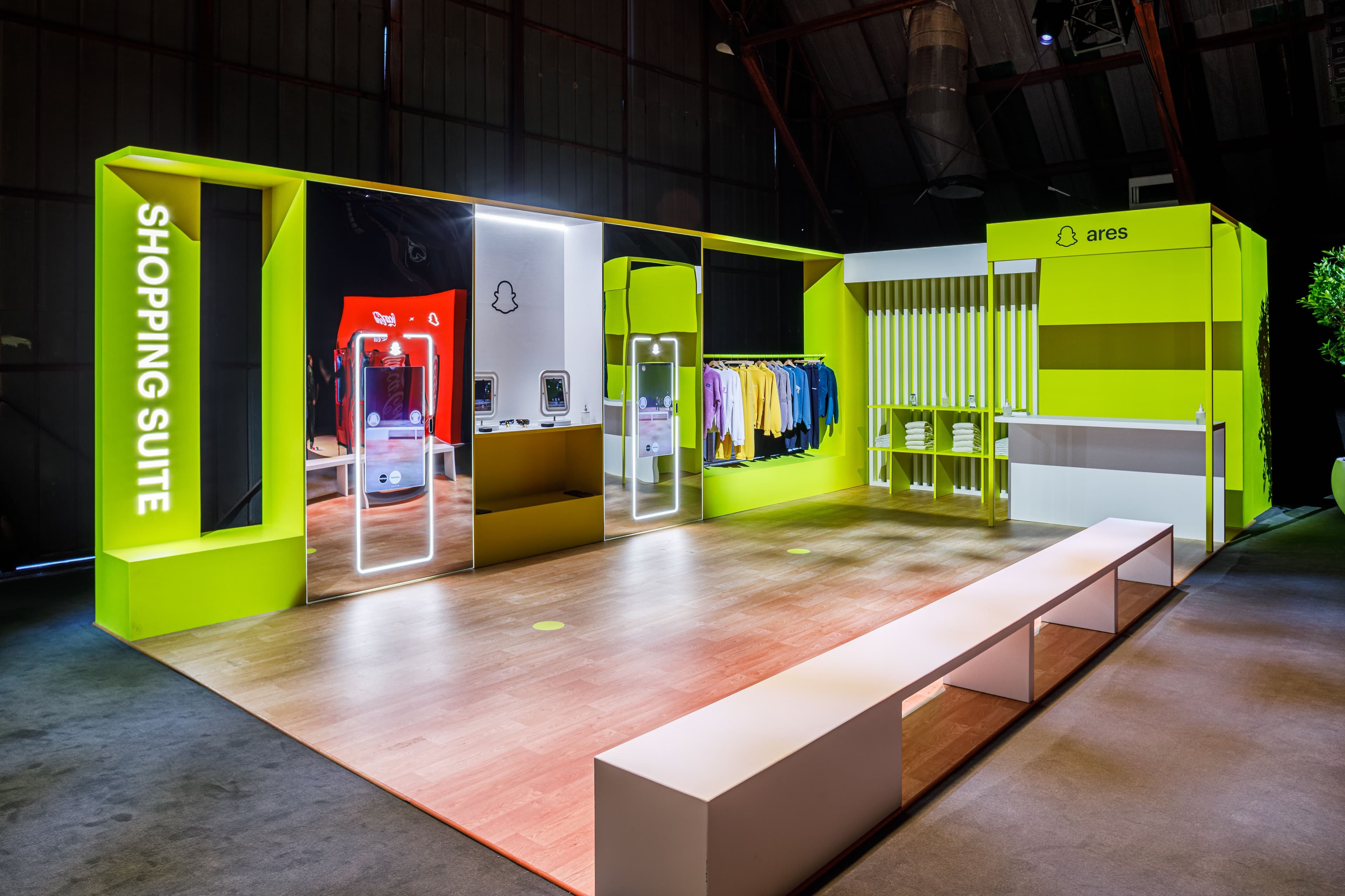 Green-lit retail display booth labeled 'Shopping Suite' with mounted screens.