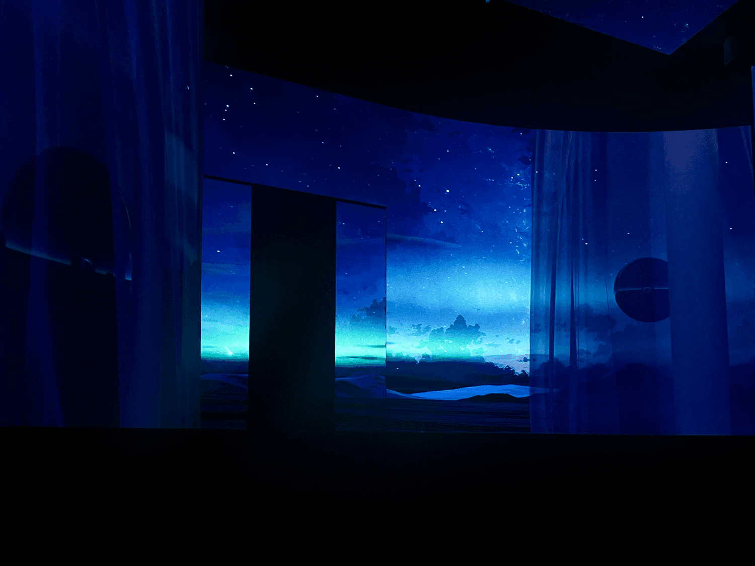Blue-lit stage panels arranged with a glowing doorway effect