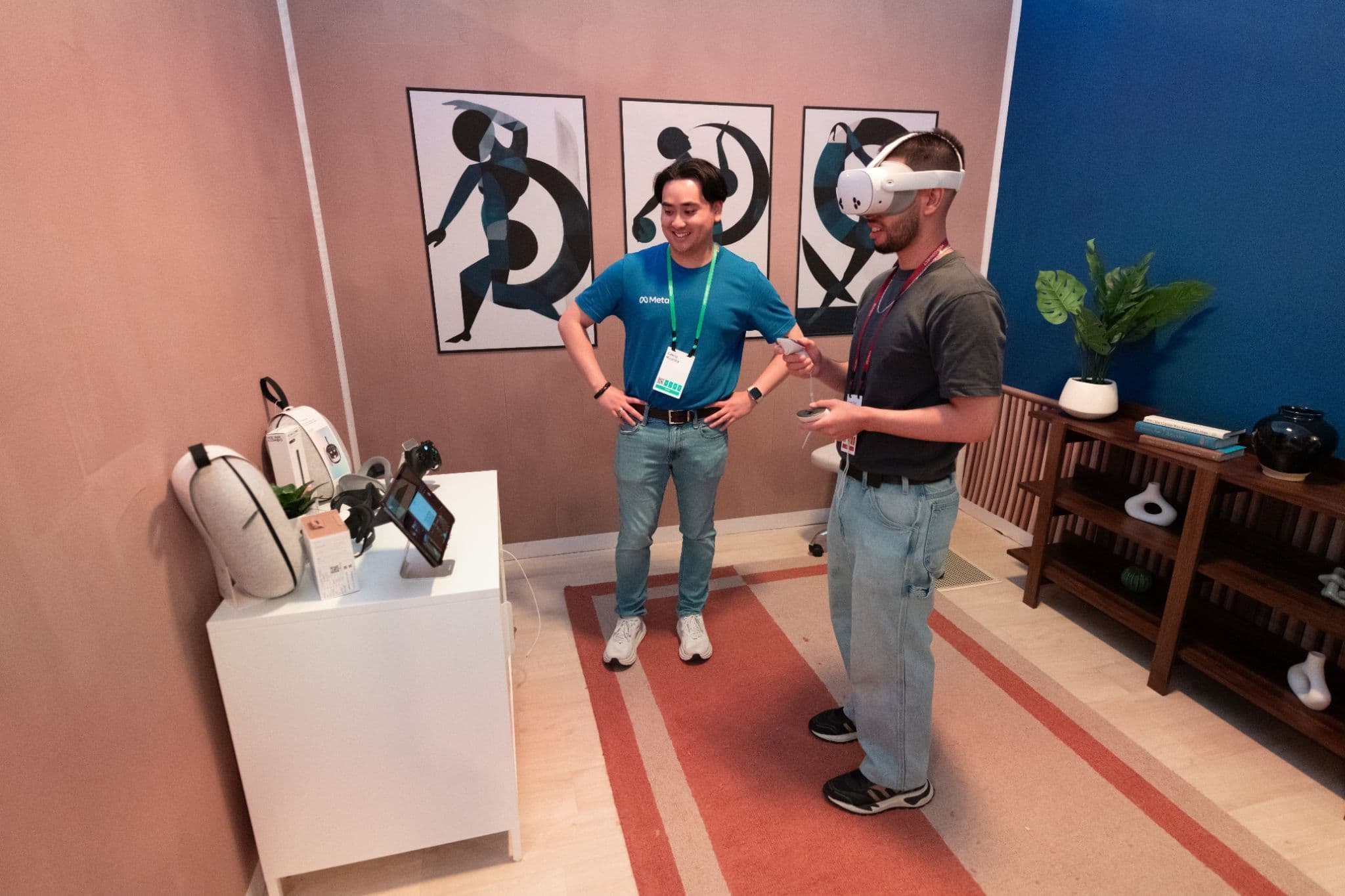 Two men in a lounge-like exhibit space demonstrating a VR headset.