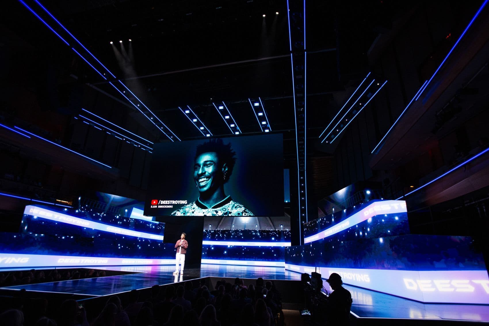 Stage screen showing a portrait beside blue curved lighting elements