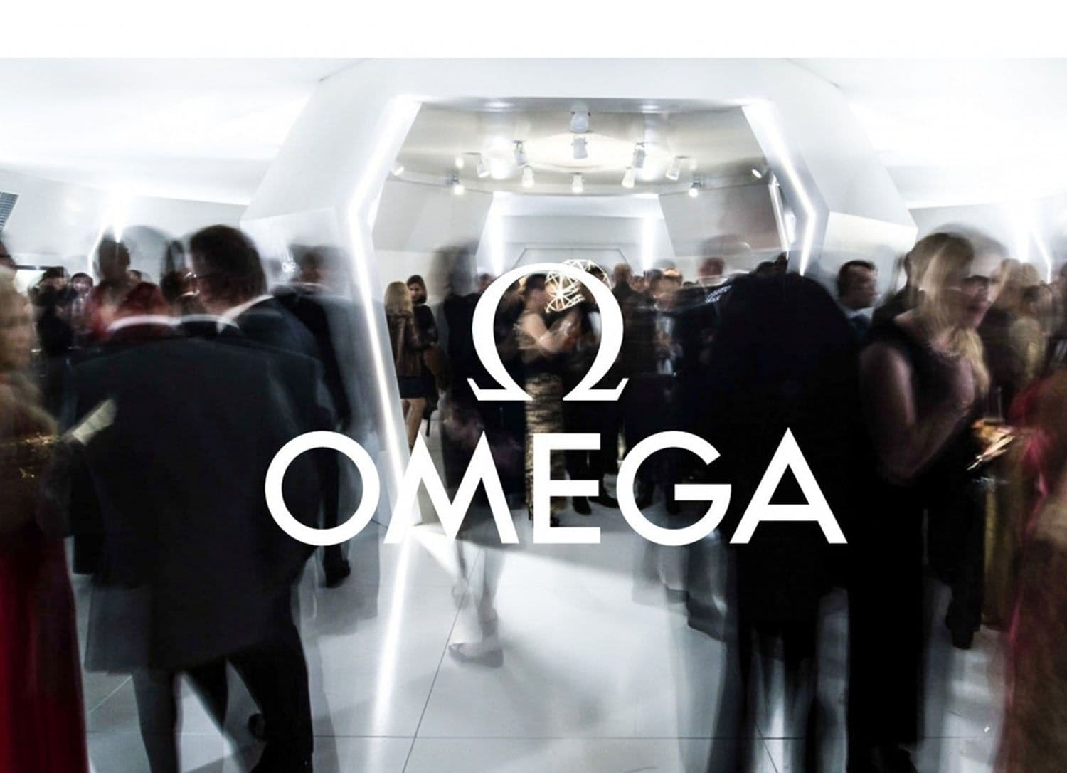 Illuminated OMEGA logo above a crowd of gala guests inside a white honeycomb-shaped entrance.