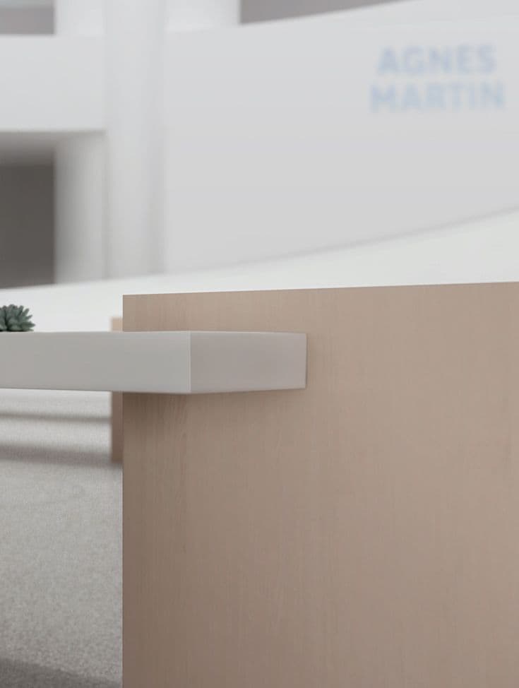 Close-up of a wood counter edge with the Agnes Martin exhibition wall text blurred in the background