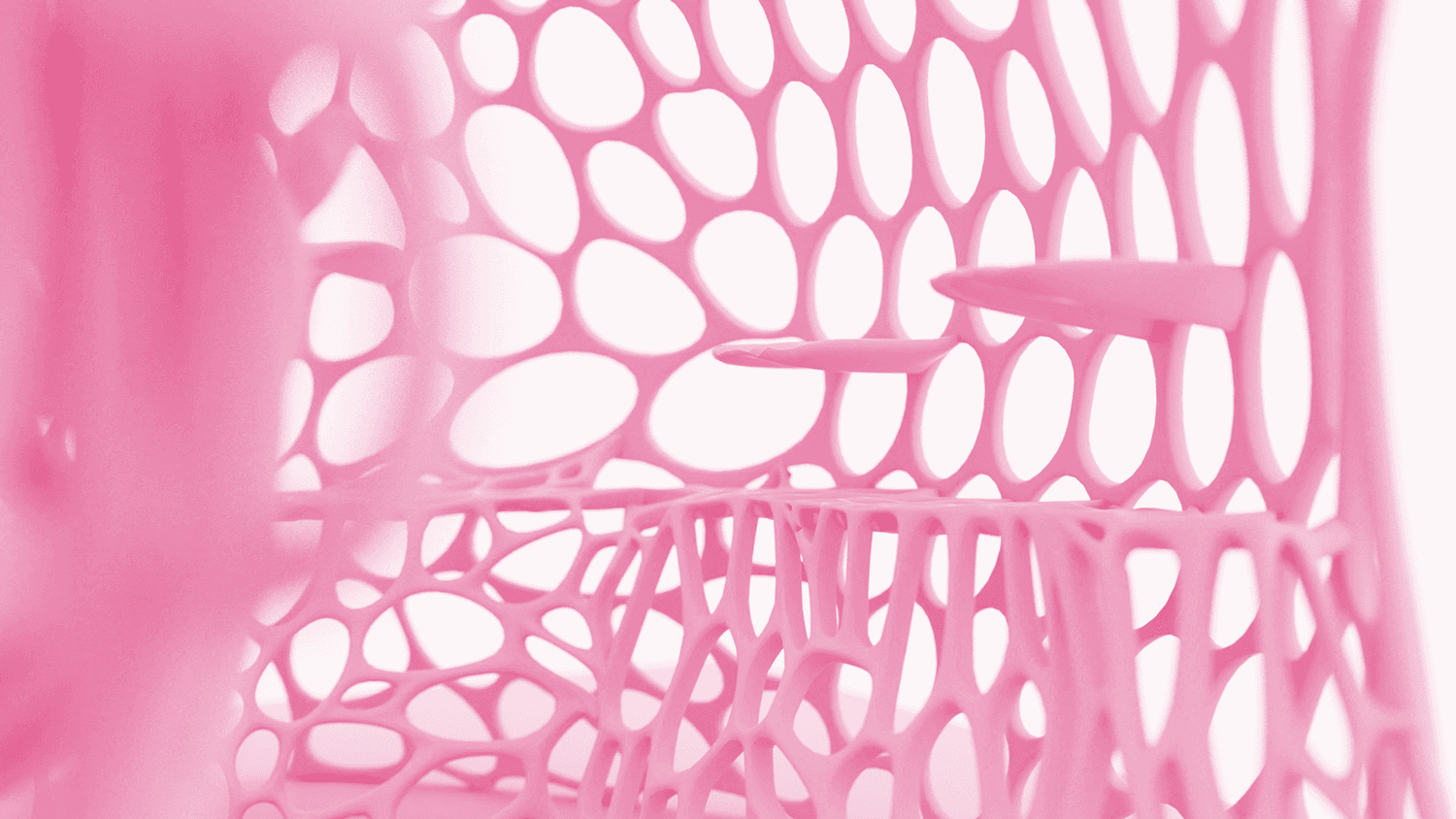Close-up of the pavilion's perforated pink lattice shell forming an oval-cell honeycomb pattern.