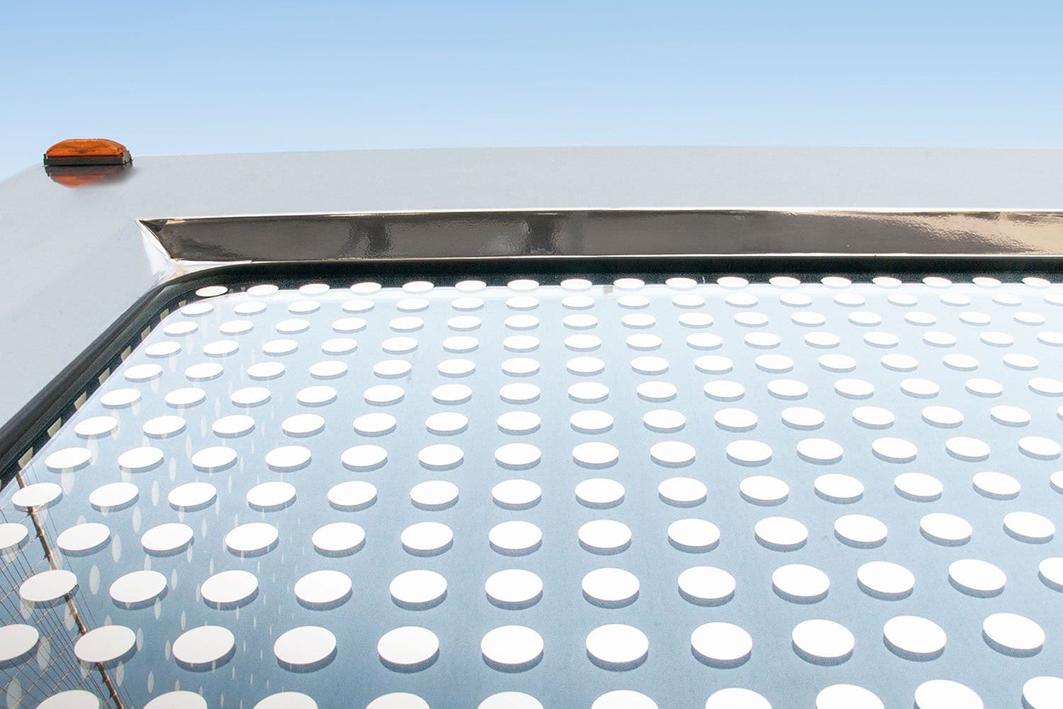 Close-up of the truck's perforated roof panel against a blue sky